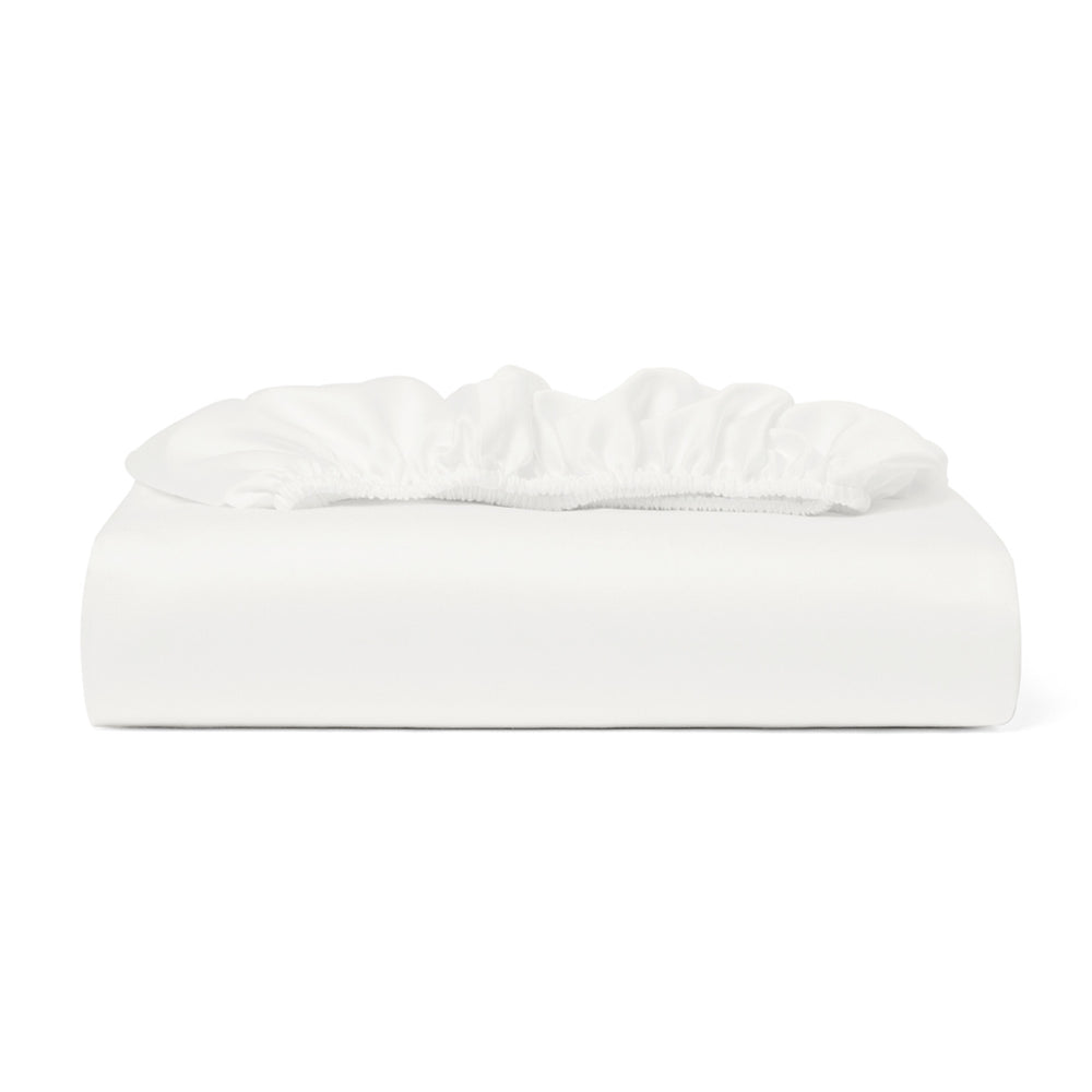 White fitted sheet on a bed with a white background