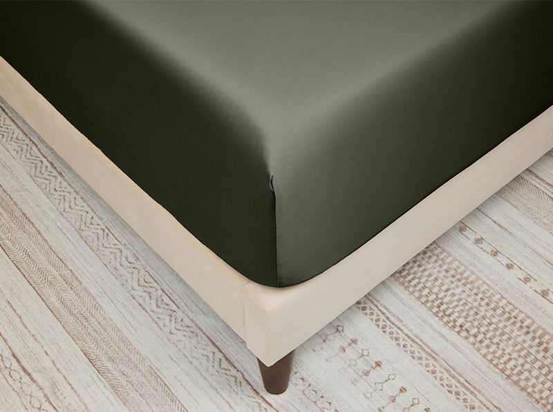 Close-up of an olive green fitted sheet on a bed corner, tightly stretched for a smooth and snug fit.